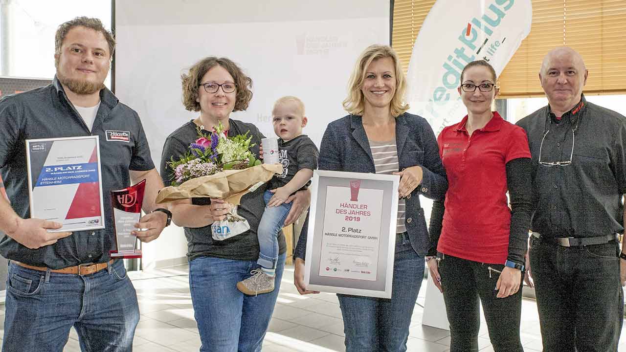 Daniel Korell und Sabine Hänsle (mit Töchterchen Johanna) von Hänsle Motorradsport wurden für ihre Leistungen, die sie zu Rang Zwei im Wettbewerb „Händler des Jahres“ führten, von Alina Kügler (Total Deutschland) gewürdigt – Urkunde und zwei Fass Motoröl als Anerkennungspreis inbegriffen. Katharina Klein und Klaus Hüttinger überreichten Pokal und Ehrenurkunde.