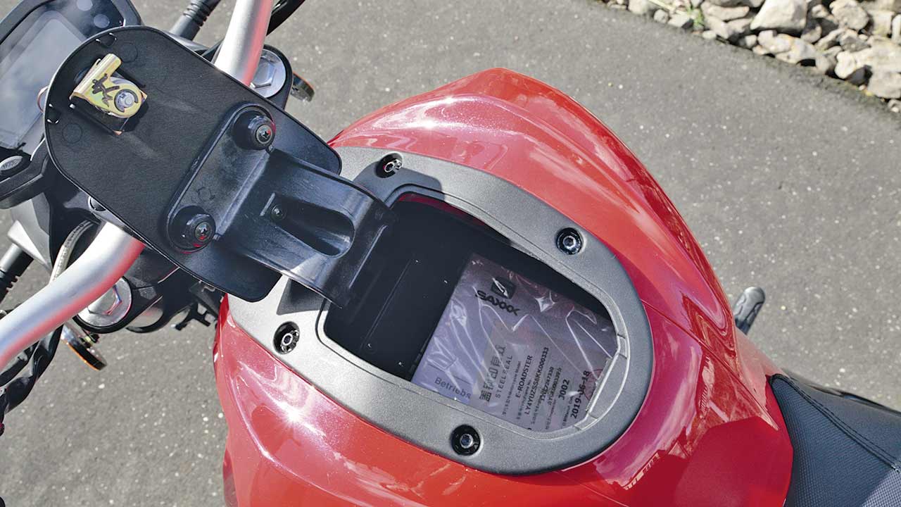 Dort, wo beim Verbrenner der Tankstutzen sitzt, offeriert der E-Roadster ein kleines, praktisches Staufach.