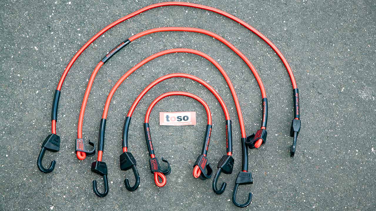 Das toso-Spannriemen-Sortiment auf einen Blick: Mit verschiedenen Hakenformen, aber einem einheitlichen Schutzmerkmal – den verschiebbaren „Safety Tubes“, mit denen sich potenzielle Scheuerstellen entschärfen lassen.