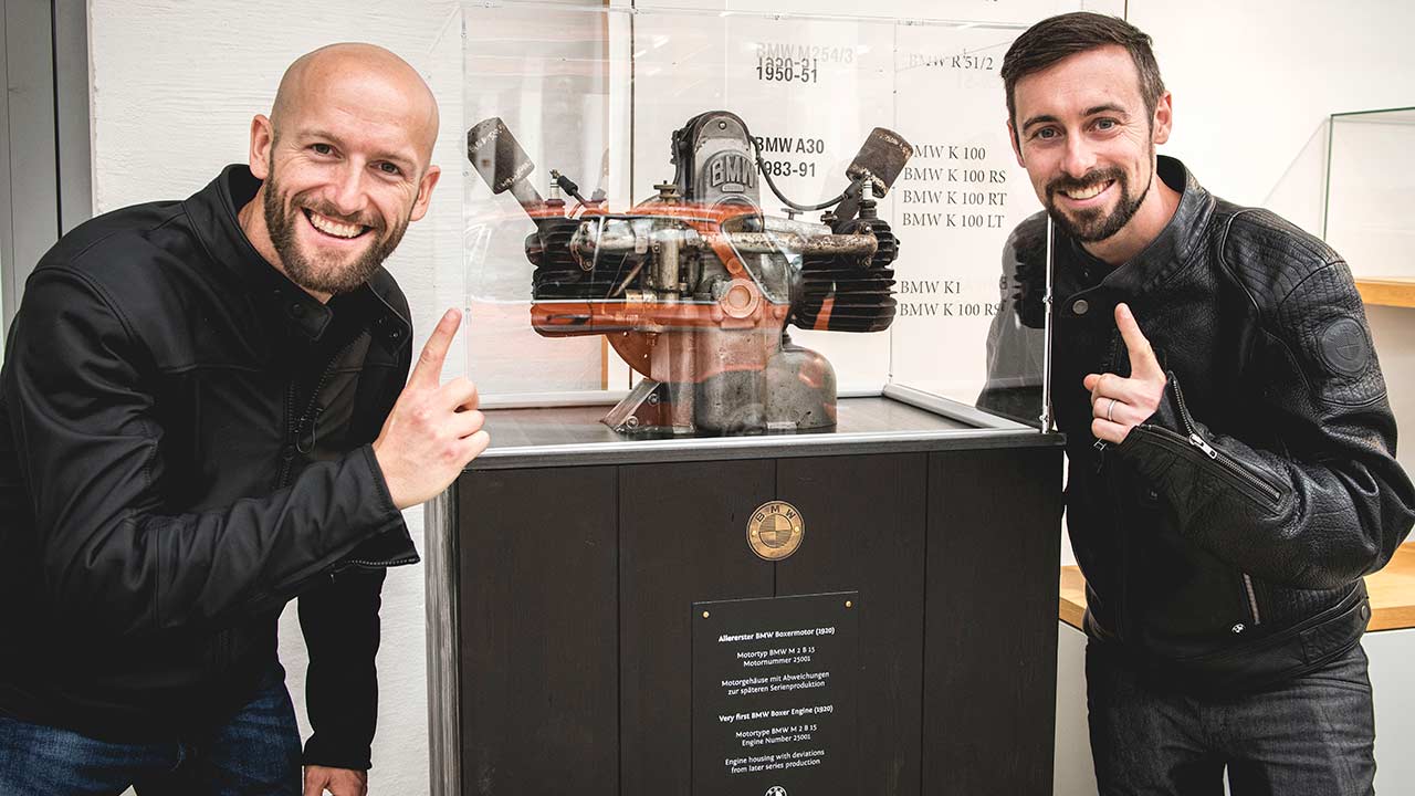 Die beiden Superbike-Profis Tom Sykes (li.) und Eugene Laverty flankieren den Ur-Boxermotor, der vor 100 Jahren das Motorrad-Zeitalter bei BMW einläutete.